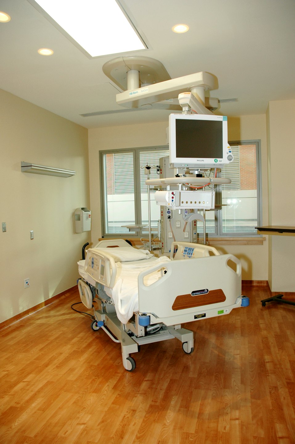 Habitación de hospital vacía con cama moderna y equipo médico.