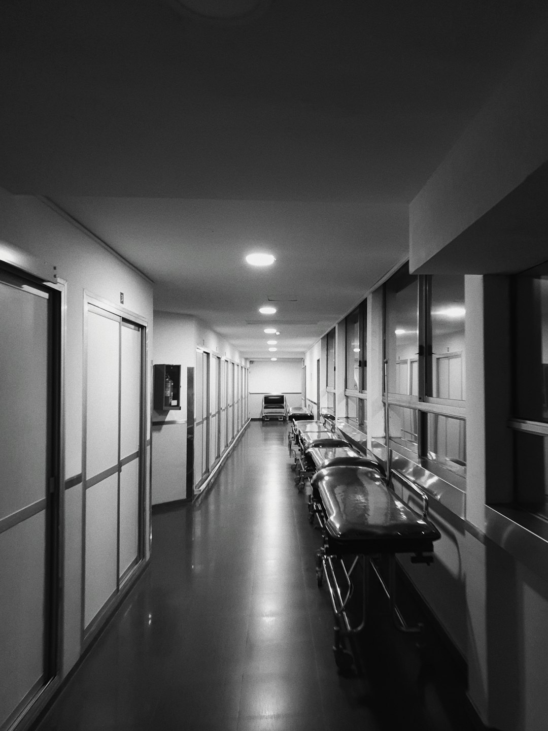 Camillas de hospital vacías en el pasillo de un centro médico estéril.
